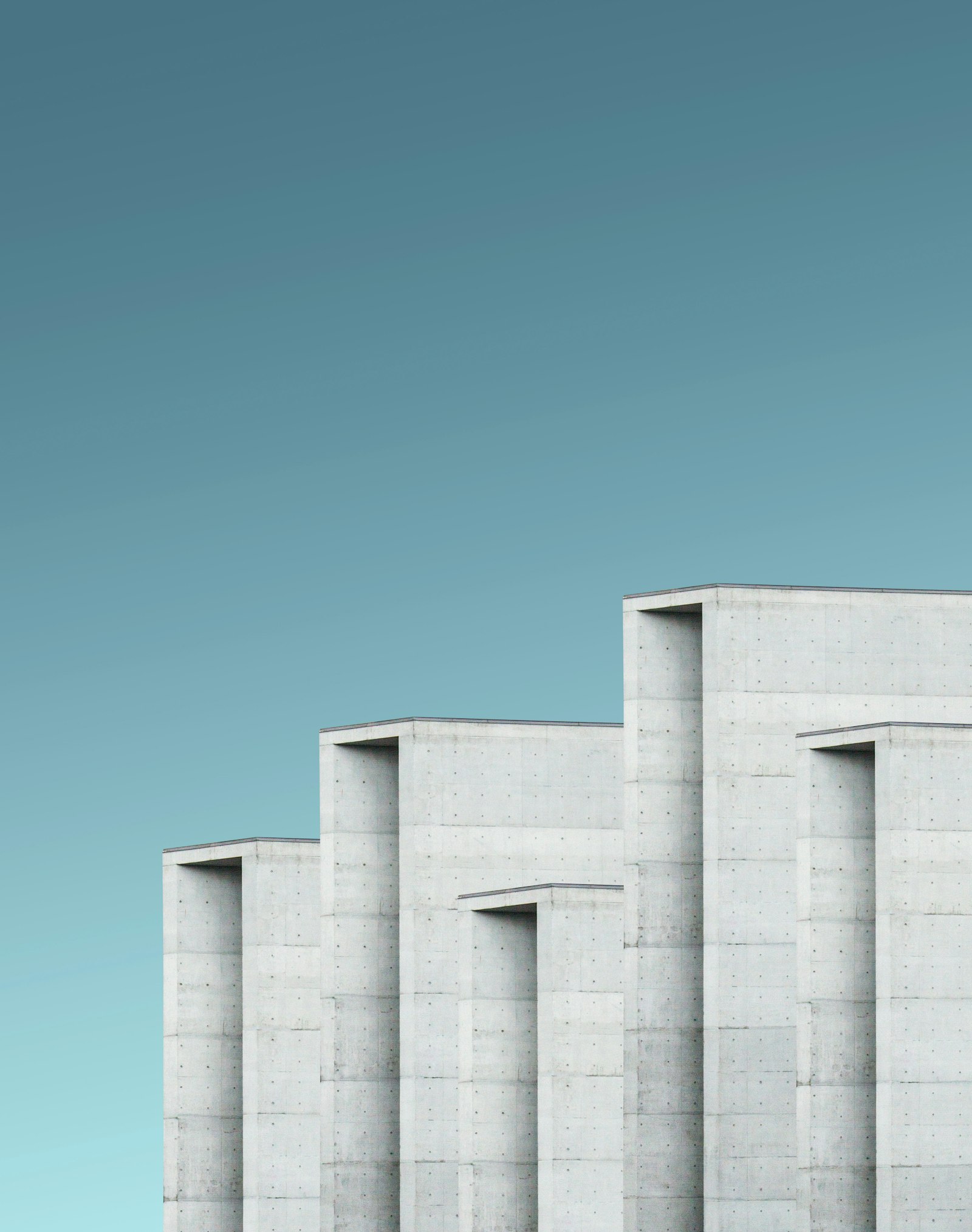 Graue Betonfassade mit geometrischer Struktur